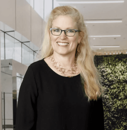Portrait of a staff member with glasses and a gold necklace.